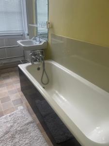 a bathroom with a bath tub and a sink at Brightling Park in Brightling