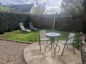 two chairs and a table and two chairs in a yard at Le refuge du chat endormi in Goderville