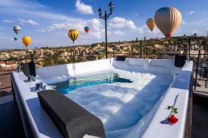 a hot tub with hot air balloons in the sky at Aurelia Cave Cappadocia - Special Class in Nevşehir