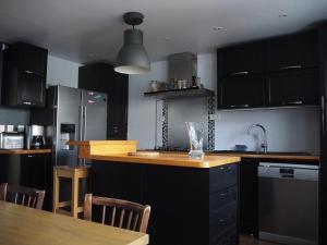 a kitchen with black cabinets and a wooden counter top at La Saline in Le Palais