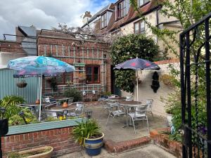 a patio with tables and chairs and umbrellas at Sams Wine Bar Harwich ltd in Harwich