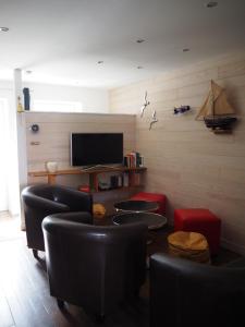 a living room with black chairs and a television at La Saline in Le Palais