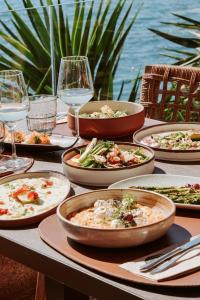 a table with plates of food and glasses of wine at Lost Seaside Hotel - Adults Only in Sarandë