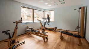 a gym with three exercise bikes in a room at Parkhotel Margna Superior in Sils Maria