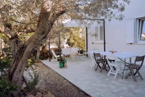 a patio with a table and chairs under a tree at Casa Verde Oliva - WelcHome in Rocca San Giovanni