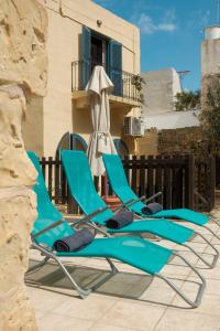 a row of blue lounge chairs on a patio at Historic Villa with a Private Pool in Mosta