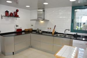 a kitchen with white cabinets and a sink at Villa Kala in Sant Pere de Ribes +55 photos