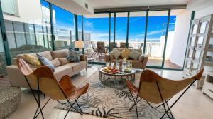 a living room with a couch and chairs and glass windows at Villa Kala in Sant Pere de Ribes