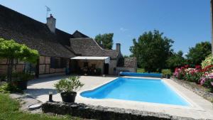 a swimming pool in front of a house at L'Auberge de Reullée in Marigny-lès-Reullée