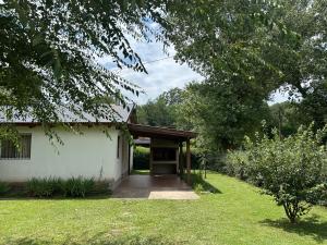 a small white building with a door in a yard at Los Manzanos in Villa Ciudad Parque