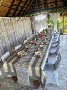 a long long table with white chairs and plates at Muco Guest House in Johannesburg