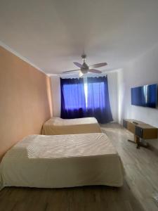 a bedroom with two beds and a ceiling fan at Departamento cómodo y totalmente equipado, ideal para familias, grupos o viajes laborales in Santa Fe