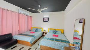 a bedroom with two beds and a mirror at Dhanmondi Lake View Hotel in Dhaka