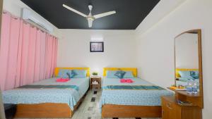 a bedroom with two beds and a mirror at Dhanmondi Lake View Hotel in Dhaka