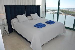 a bedroom with a bed with two blue towels on it at Villa Kala in Sant Pere de Ribes
