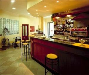 a bar in a restaurant with bar stools at Hotel Adriatico in Bellaria-Igea Marina