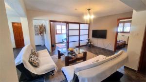 a living room with two white couches and a tv at katerina's Villa in Nikiti +7 photos