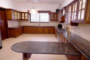 a large kitchen with wooden cabinets and a granite counter top at Elevé Stays - Boutique Family Suites in Karachi