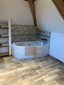 a bathroom with a bath tub in a room at L'Auberge de Reullée in Marigny-lès-Reullée