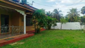 a house with a yard next to a fence at Aqua Dream Adventures Resort in Trincomalee