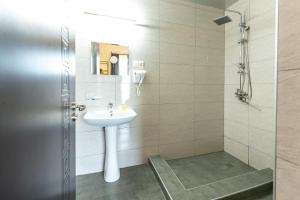 a bathroom with a sink and a shower at Mestia HOTEL AMIRANI in Mestia