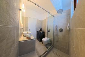 a bathroom with a shower and a toilet and a sink at Elani Blue Coast Maisonette in Elani +40 photos