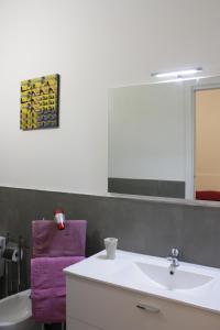 bagno con lavandino bianco e asciugamano viola di Camere Andrea a La Spezia