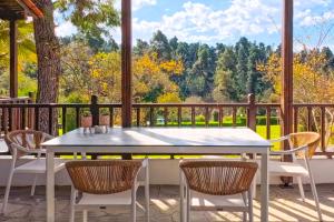 a table and chairs on a porch with a view at Elani Blue Coast Maisonette in Elani