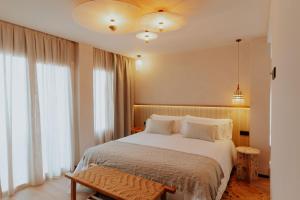 ein Schlafzimmer mit einem großen weißen Bett und Fenstern in der Unterkunft Hotel Meridional in Guardamar del Segura