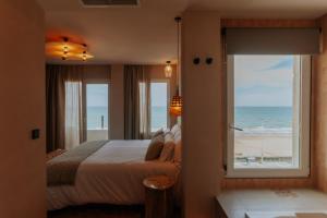ein Schlafzimmer mit einem Bett und Blick auf den Strand in der Unterkunft Hotel Meridional in Guardamar del Segura + 69 Fotos