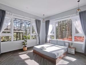 a bedroom with a large bed and two windows at AP HOME - Lakeside in Ấp Ðinh An (1)
