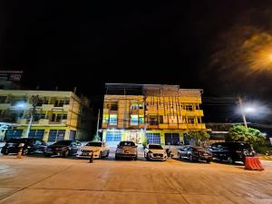 a parking lot with cars parked in front of a building at SB The Moon Night Betong in Betong +16 photos