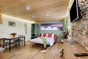 a bedroom with a bed and a table and a dining room at Mes Anges Perloz in Pont-Saint-Martin
