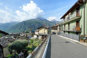 a street in a village with mountains in the background at Mes Anges Perloz in Pont-Saint-Martin