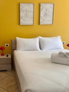 a bedroom with a white bed with two pictures on the wall at Slate House & Terrace - 6 min walk to Bernina Express in Tirano