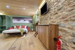 a bedroom with a bed and a stone wall at Mes Anges Perloz in Pont-Saint-Martin