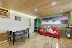 a living room with a red couch and a table at Mes Anges Perloz in Pont-Saint-Martin