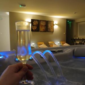 a person holding a wine glass in front of a tub at Celessentielle à 10 min de Pairi Daiza , gîte romantique in Jurbise