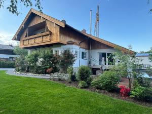 a house with a balcony on top of a yard at Landhaus Falkennest in Flintsbach am Inn
