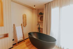 eine schwarze Badewanne in einem Zimmer mit Fenster in der Unterkunft Hotel Meridional in Guardamar del Segura