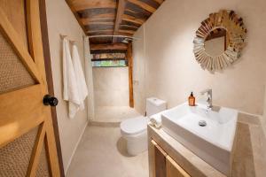 a bathroom with a sink and a toilet and a mirror at Treehouse Tulum H2Ojos in Tulum