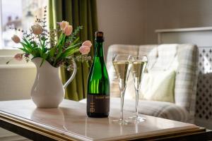 a bottle of champagne and two glasses on a table at The Bull Inn in Woodbridge +65 photos