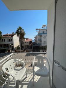 two white chairs on a balcony with a view at Tiffany Otel in Özdere +1 photo