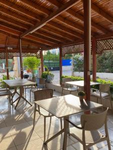 a patio with tables and chairs under a wooden roof at Tiffany Otel in Özdere