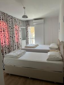 two beds in a room with a window at Tiffany Otel in Özdere