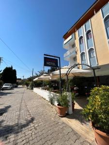 a sign for a hotel on a street with plants at Tiffany Otel in Özdere