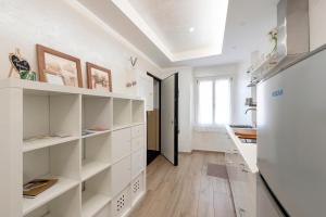 a white kitchen with white shelves and a window at The Hemme's Home in Genoa
