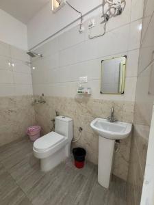 a bathroom with a toilet and a sink at The Jade Inn in Gopeshwar