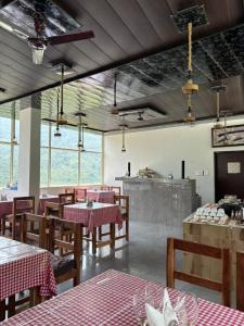 a restaurant with tables and chairs in a room at The Jade Inn in Gopeshwar