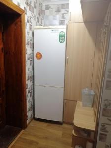 a white refrigerator in a corner of a kitchen at Квартира in Sumy